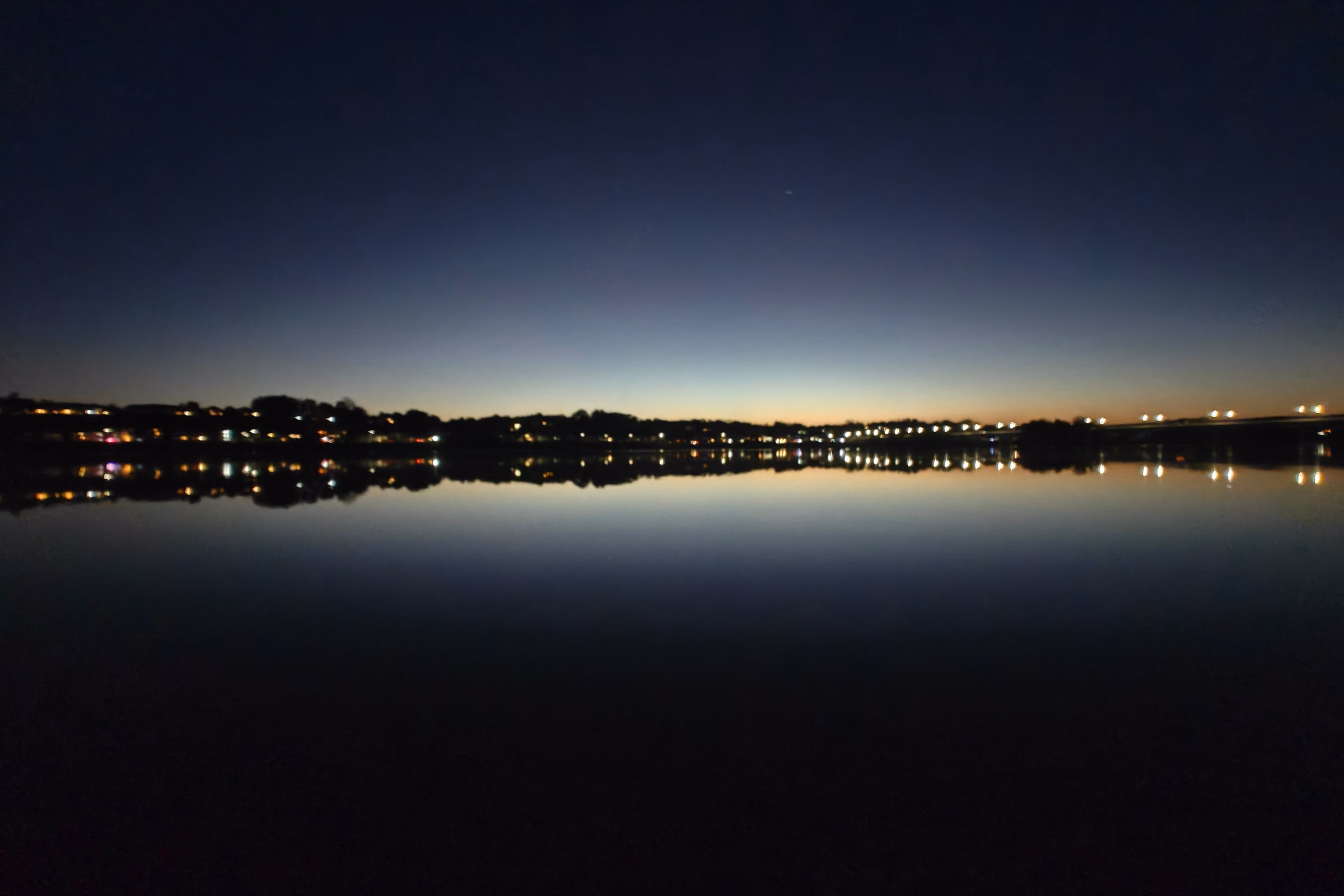 Bridge lights and their reflections cross the Susquehanna River at blue hour near Harrisburg.
