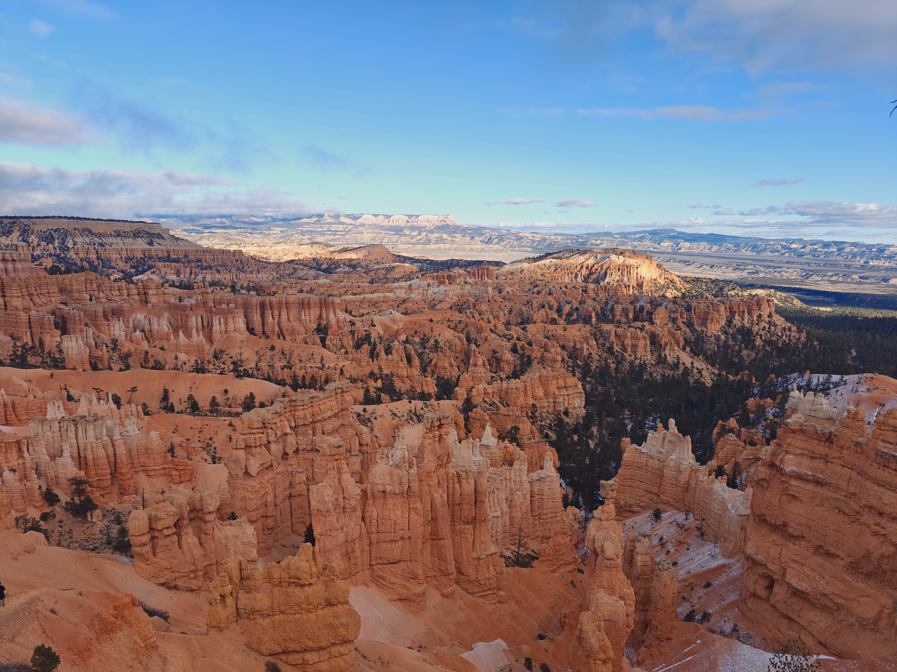 Bryce Canyon hoodoos fill a deep amphitheater as winter light opens on the distant plateau.