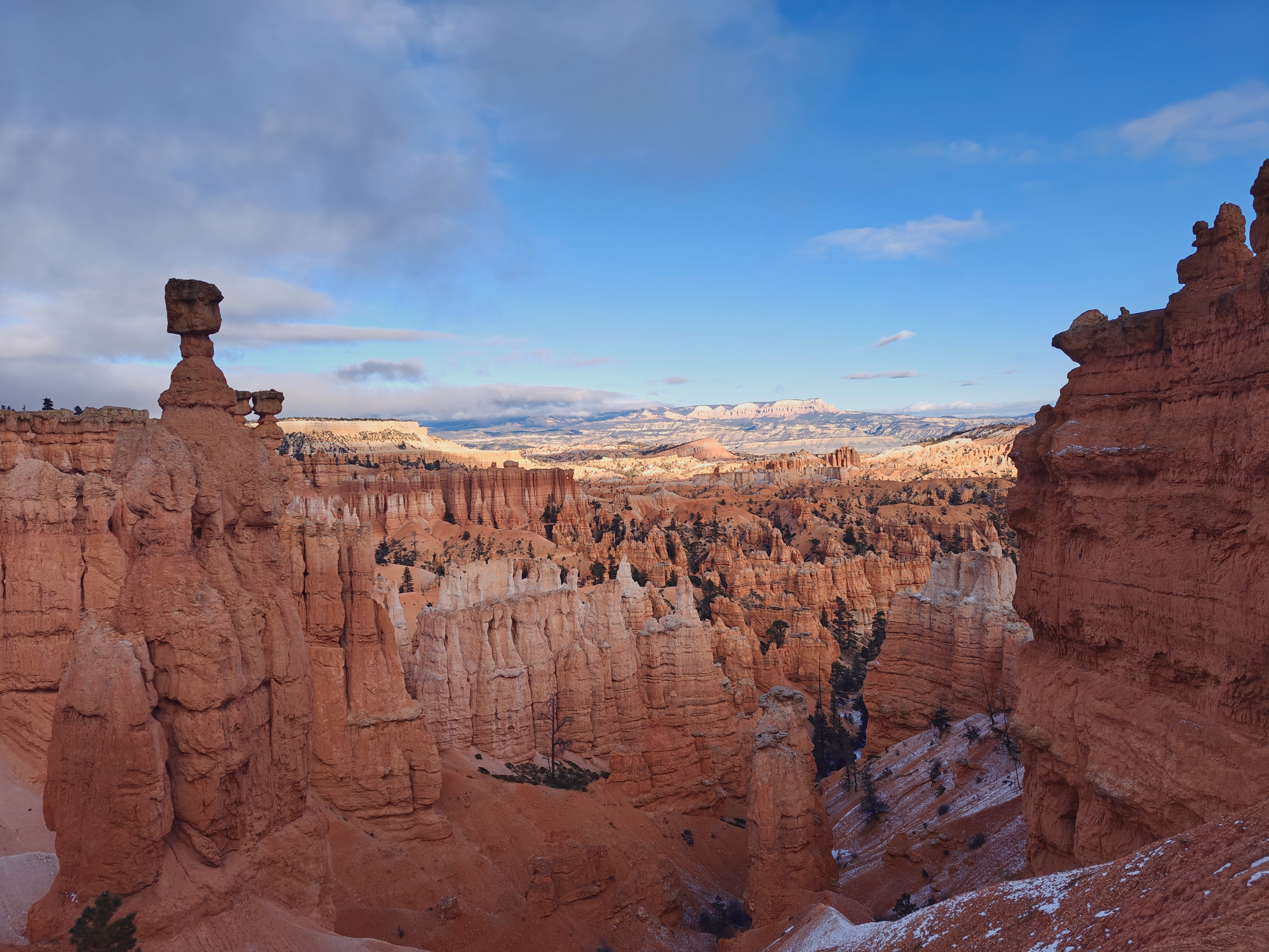 Balanced hoodoo towers frame a sunlit winter plateau above Bryce Canyon.